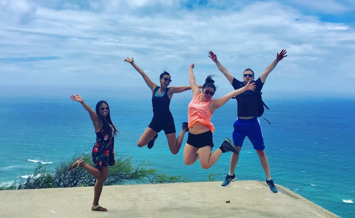 Four people jumping from joy near a cliff