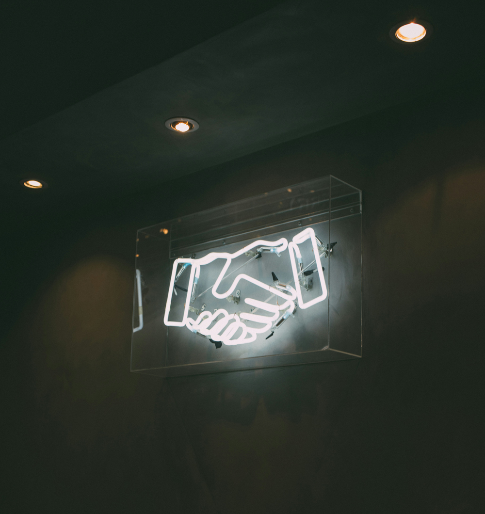 neon sign of a handshake