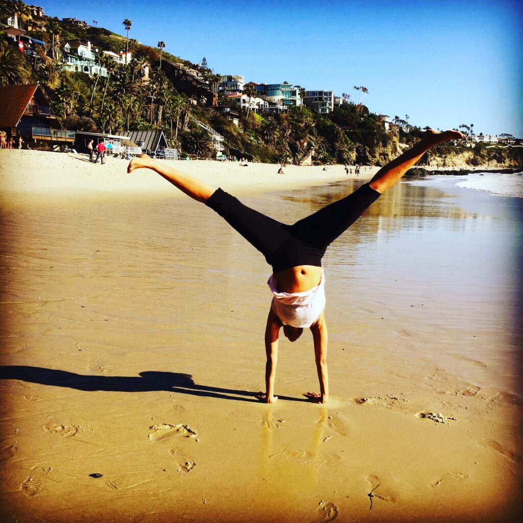 Ebony in a handstand at the beach